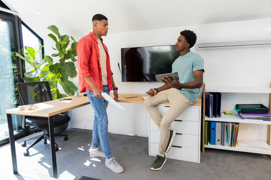 Reviewing documents and using tablet in modern office, with wood desk and binders