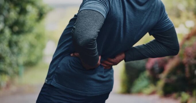 Man, runner or back pain with fitness injury for discomfort, strain or overworked stress in nature. Male person, athlete or sore spine with inflammation or ache for muscle tension or outdoor accident