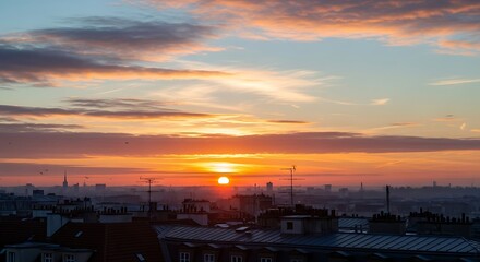 Fototapeta premium Vibrant orange sunset over cityscape horizon.