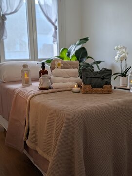 Minimalist cozy spa treatment room with towels and massage bed