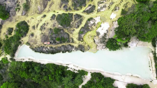 Bagno Vignoni natural pools along the city hill in Tuscany, overhead view in spring season from drone