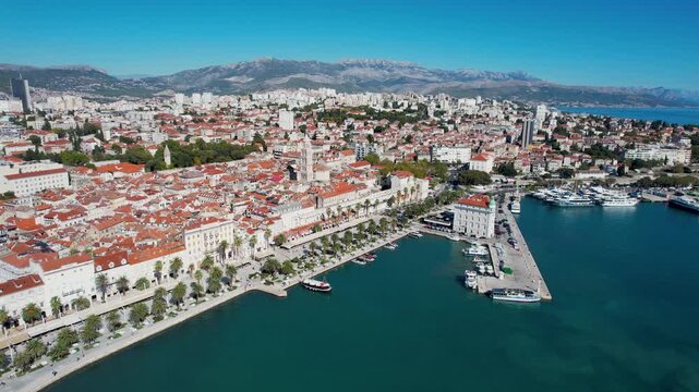Aerial view of red rooftops meet the turquoise sea, with Diocletian's Palace in the centre and boats bobbing gently in the harbor near Riva promenade, Split, Dalmatian Coast, Croatia.
