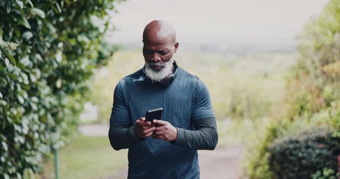Senior, black man and fitness with phone in nature for workout app or monitoring performance. Active, elderly or African male person scrolling with mobile smartphone for exercise routine or schedule