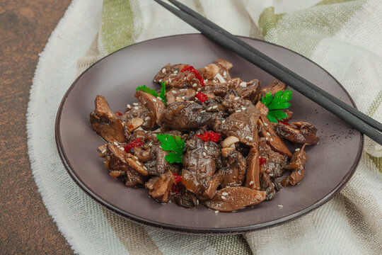 Delicious Shimeji mushrooms with chili pepper, sesame seeds and greens. Healthy Umami vegan food