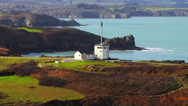Aerial view of Pointe du Grouin semaphore building on the rugged cliffs overlooking the turquoise waters of the Emerald Coast Cancale, Bretagne, France.