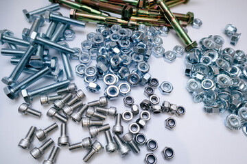 Assortment of metal bolts nuts and anchors on white background, industrial hardware collection