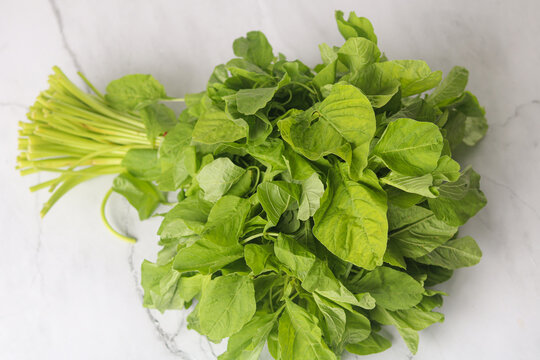 Top view of fresh spinach leaves bundled together, showing vibrant green color and natural texture.