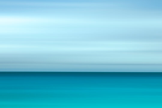 Soft gradient sky meets calm turquoise ocean horizon. Serene, peaceful atmosphere evokes tranquility and relaxation. Ideal for travel, wellness