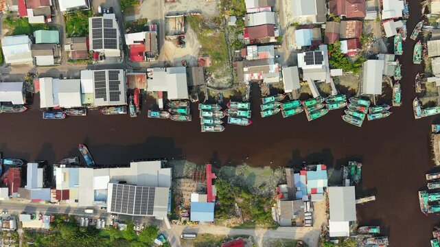 Top Down Drone View Fishing Boats And Solar Roof In Fishing Village Sekinchan Malaysia. Coastal fishing industry and renewable energy infrastructure in Southeast Asia.