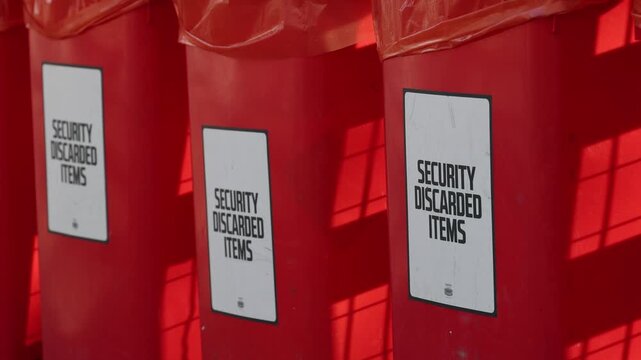 Discarded items bin on event with security, confiscated items in the trash