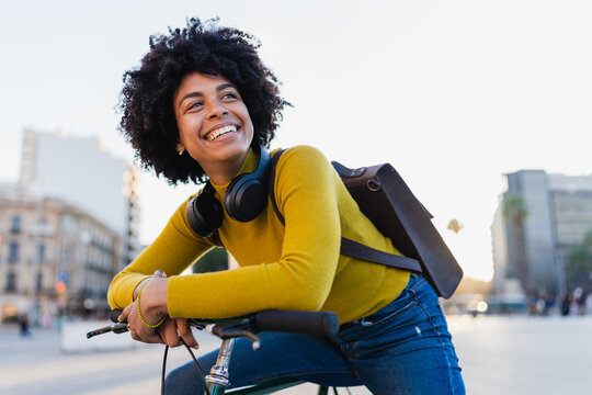 Happy black woman enjoying urban bicycle ride in city