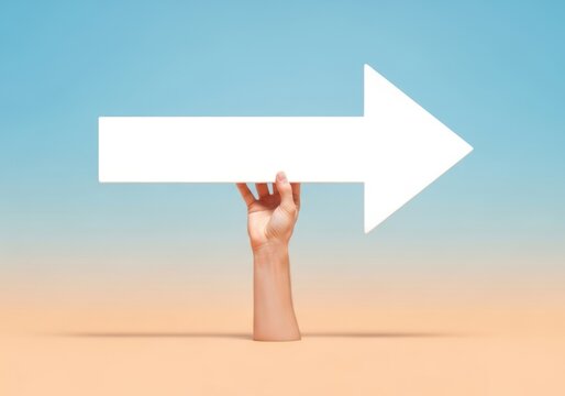 Hand holding a large white arrow against a gradient sky background