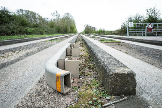Interesting view of a concrete and metal guided busway track in Britain. The barriers keep the fast moving bus without the driver needing to steer.