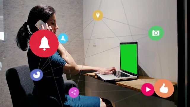 Midadult woman holding phone, typing on tech laptop, call launching app icons, bell showing alerts