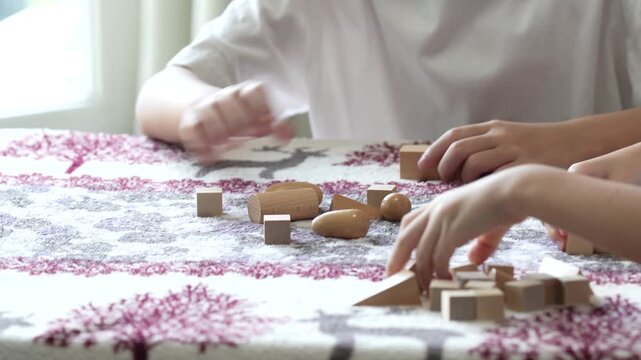 Children play with wooden blocks at a table in a calm home environment supporting creativity, learning, and early childhood development.