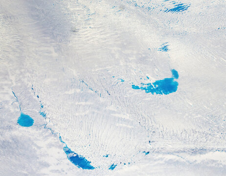 Aerial view of glacial meltwater pools shimmering like sapphires against the stark white canvas of ice and snow, creating a breathtaking spectacle of nature's artistry, Narsarsuaq, Greenland.