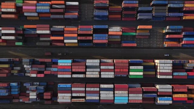 Aerial view of neatly stacked shipping containers showcasing a vibrant tapestry of colors and patterns in an industrial landscape, Setubal, Portugal.