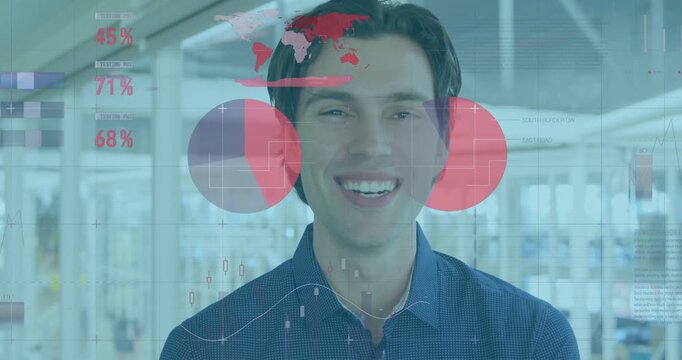 Smiling man in dark blue button-up shirt laughing, tilting head at bright office with red charts