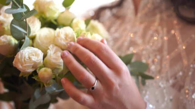 Wedding bouquet with white roses and green leaves. Bride in dress holds bouquet. Advert for wedding agency