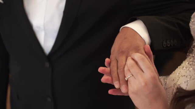 Closeup the intimate moment of bride and groom exchanging wedding diamond rings during wedding ceremony. Beautifully symbolizes love, commitment, and beginning of lifelong journey together