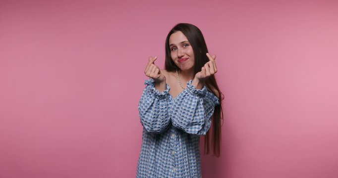 Girl smiles and gestures with hands in simple actions against a pink background