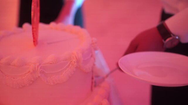 female and male hands cutting a wedding cake