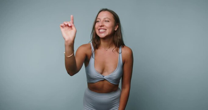 Woman shows sign language gestures in studio setting during daytime for communication purposes