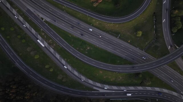 Aerial view of the highway interchange reveals a network of roads amidst green spaces, creating a complex yet organized scene, Porto, Portugal.