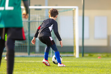 Youth Soccer Training Near Goal; Kid Practicing Dribbling with Coach on Football Field