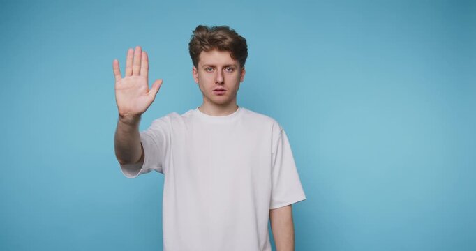 Man shows hand signs against blue background in simple communication and expression