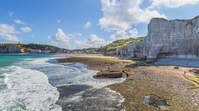 Aerial view of dramatic white cliffs meet the turquoise sea, a dance of light and shadow on the rugged coastline, Etretat, Normandy, France.