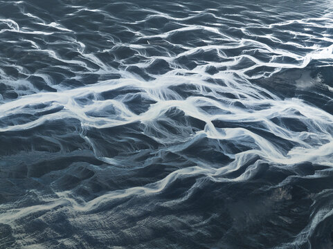 Aerial view of the ocean's surface, a symphony of rippling waves reflecting light, creating a mesmerizing dance of blues and whites, Iceland, Iceland.