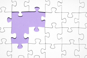 Fototapeta premium White jigsaw puzzle with missing pieces on purple background