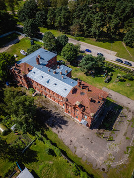 Aerial view of the imposing red-brick building stands in stark contrast to the surrounding lush greenery, Liepaja, Latvia.