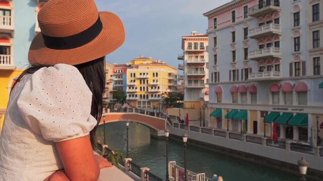 Doha, Qatar - 20th january, 2026: Woman traveler enjoy canal views in Qanat Quartier Pearl Qatar colorful Venice style architecture with canals bridges luxury waterfront lifestyle travel destination