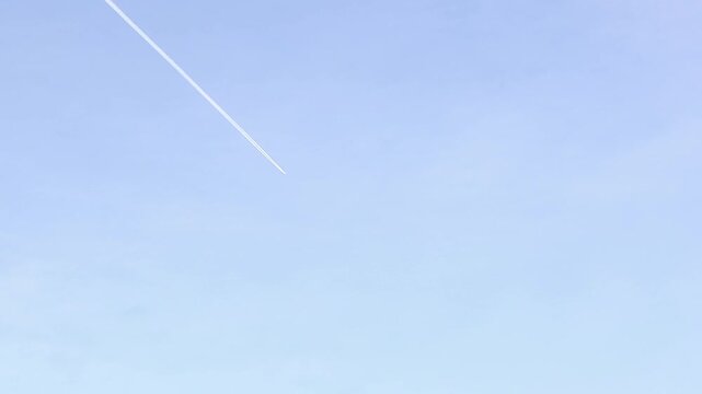 Jet contrail formed by water vapor freezing into ice crystals at high altitude, creating a visible white trail. Ideal for aviation, climate science, atmosphere, and environmental concept visuals.