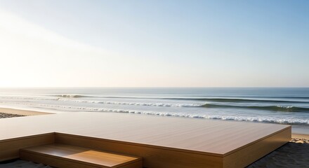 Fototapeta premium Modern wooden deck on a sandy beach overlooking the ocean with gentle waves under a clear sky