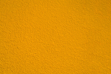Naklejka premium modern yellow gold golden new monochrome texture with grains, warm color colour wall concrete texture pattern with grainy stained, brown stucco in plaster plastering fence floor flooring