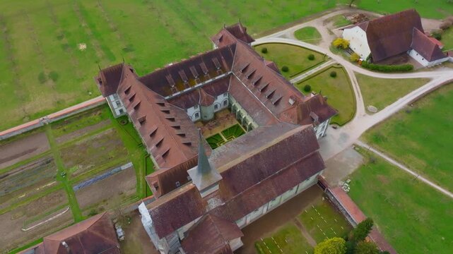 Cinematic drone orbit directly above the courtyard of Abbaye d&rsquo;Hauterive near Fribourg, revealing the monastery&rsquo;s architecture and peaceful inner space.