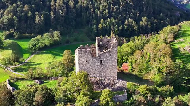 Cinematic drone flight over Wartau castle ruins near Sargans, featuring well-preserved medieval structures and nearby Swiss Reduit WWII fortifications.