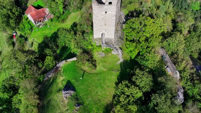 Cinematic drone flight over Wartau castle ruins near Sargans, featuring well-preserved medieval structures and nearby Swiss Reduit WWII fortifications.
