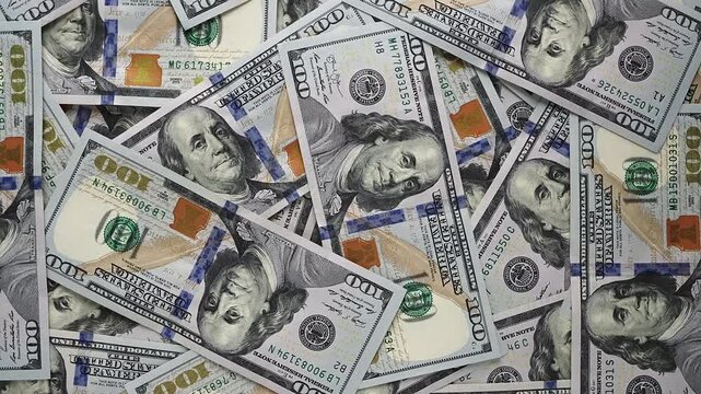 Top view spinning money background with 100 dollar bills. US treasury notes rotating in frame. Financial stability banking and wealth management concept. Crisp and clear banknote details.