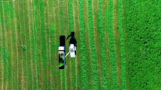 Aerial View of Agricultural Machinery Cutting Grass on a Vibrant Green Field Landscape in Finland