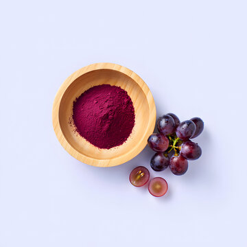 Grape powder in a wooden bowl with fresh grapes on a light background vegan protein powder