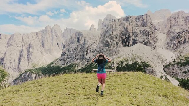 Tracking follow pov excited female fit hiker runs enjoy sunny iconic famous Italy Dolomites mountains range. Mountain trail breathtaking views iconic limestone peaks. UNESCO World Heritage site