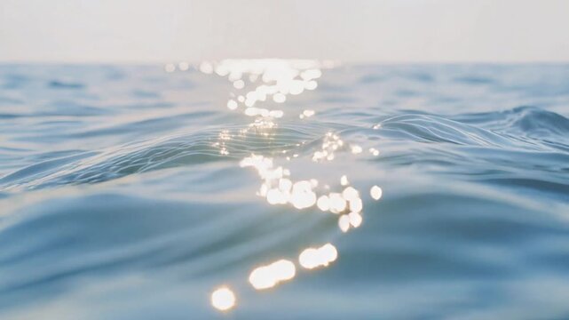 Reflections of sunlight on water, calm waves, clear water surface.
