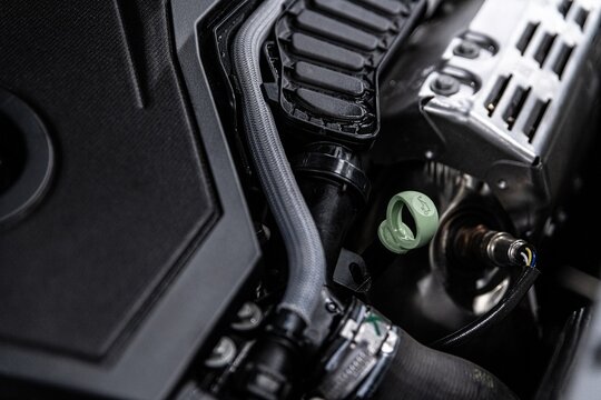 Close-up of a car engine bay with a visible oil dipstick used for checking engine oil level. Routine maintenance step ensuring proper lubrication and engine performance.