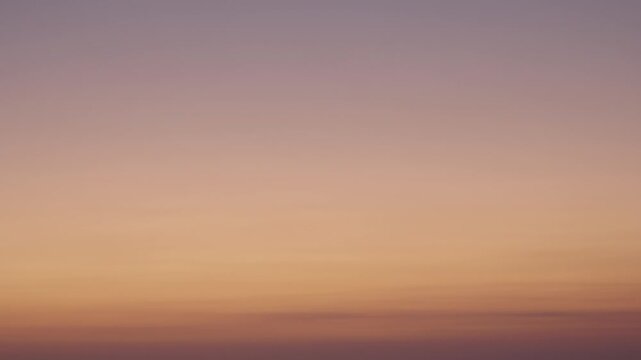 Minimal gradient sunset sky over ocean horizon with soft warm tones