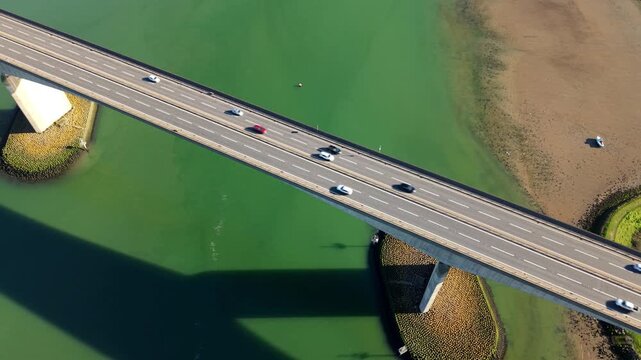 Aerial view of the Orwell Bridge, a concrete bridge with cars crossing over a body of water, Ipswich, England, United Kingdom.