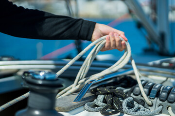 Person handling sailing rope on yacht deck © Nazareno